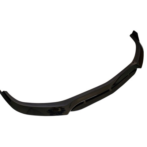 A glossy black car splitter viewed against a plain white background, showcasing its aerodynamic shape with a slightly curved design and mounting brackets.