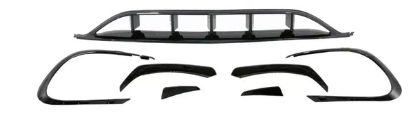 Car body kit components are arranged on a white background, including bumper covers and aerodynamic trim pieces, all in shiny black, designed to enhance vehicle appearance and performance.