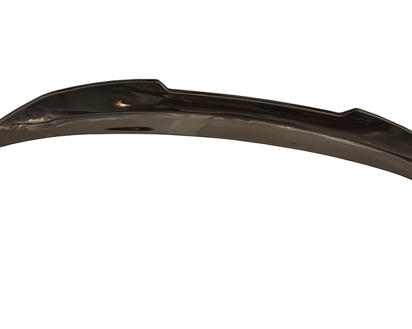 A shiny, curved metal car bumper with angular edges rests against a plain white background, suggesting it is a detached automotive part.