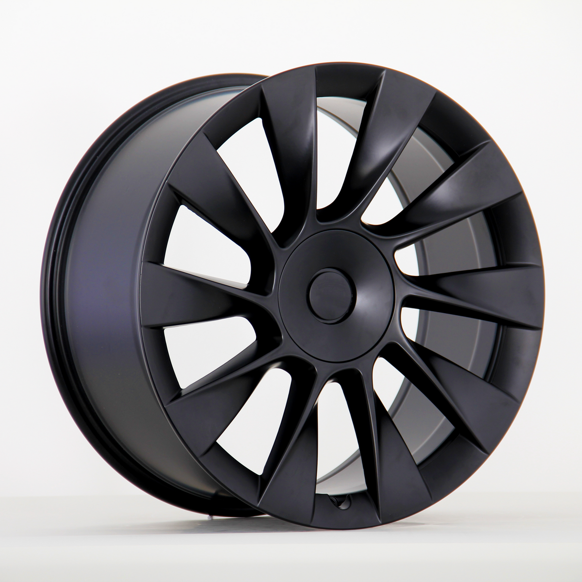 Black alloy wheel with a sleek, multi-spoke design is upright against a plain white background, highlighting its modern and aerodynamic appearance.