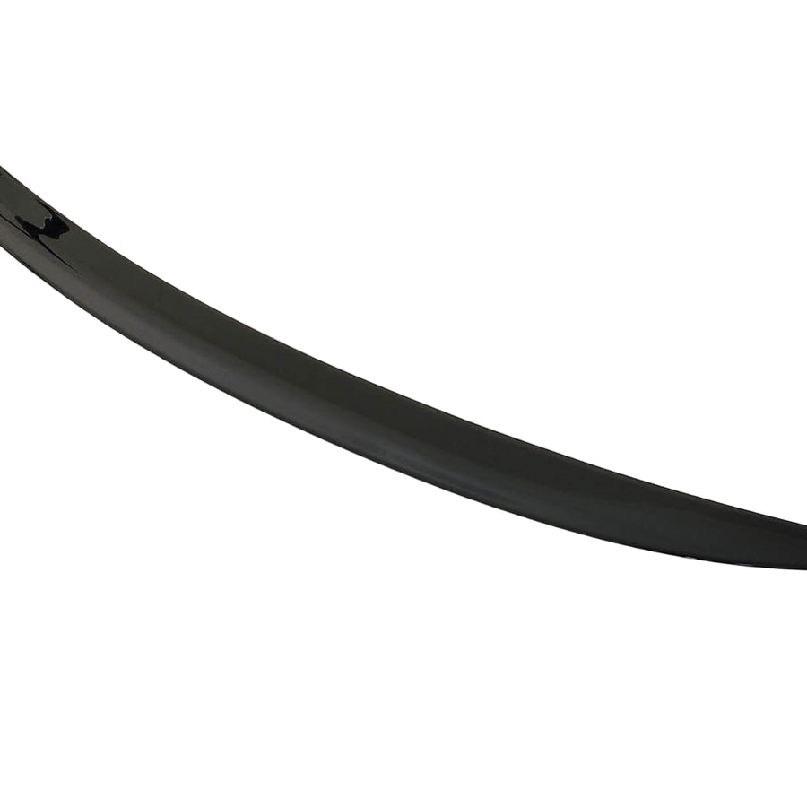 A sleek, black car spoiler lies on a plain white surface, curving slightly upward at the ends.