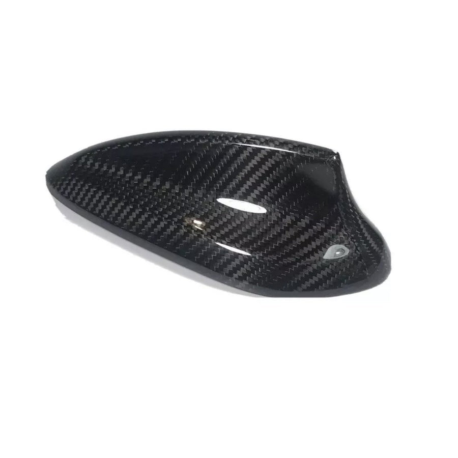Carbon fiber car side mirror cover, sleek and glossy, resting on a plain white background. The cover exhibits a distinct woven pattern and aerodynamic design, emphasizing high-performance aesthetics.