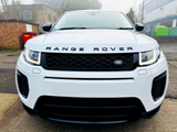 A white Range Rover, parked on a driveway, features a prominent front grille with the 