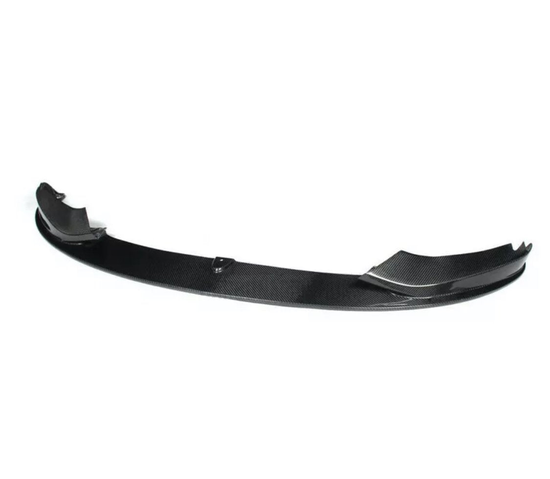 A carbon fiber car spoiler, resting on a white background, with a curved structure and raised ends designed for aerodynamic performance.