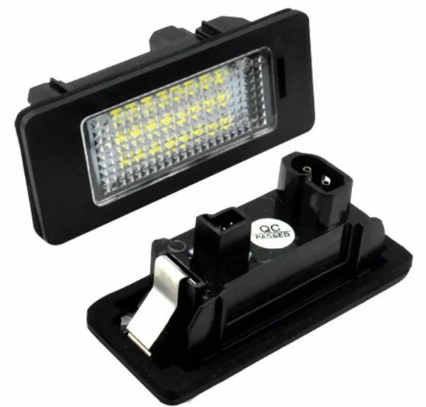 Rectangular LED light fixture with a grid of yellow diodes is connected to a black plastic housing. A "QC PASSED" sticker is visible on the back component.