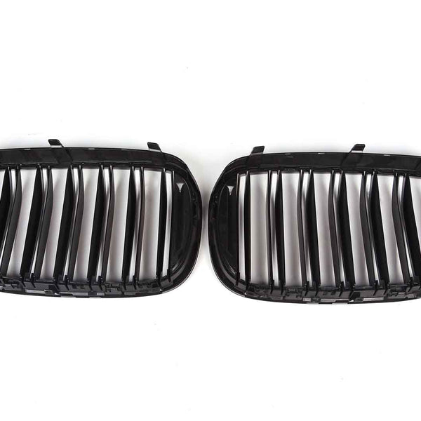 Two black car grille inserts with vertical slats lie side by side against a white background, designed to fit into a vehicle's front end for ventilation.