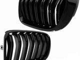 Two glossy black car grilles with vertical slats are displayed against a plain white background, showing different angles of each grille.