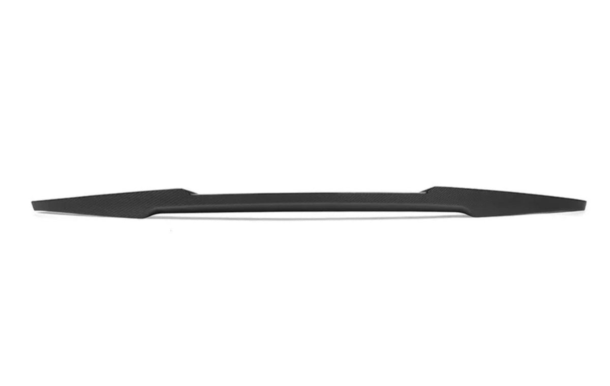 A sleek, black, elongated car spoiler rests horizontally against a plain white background, illustrating its aerodynamic shape and texture with no additional text or features.