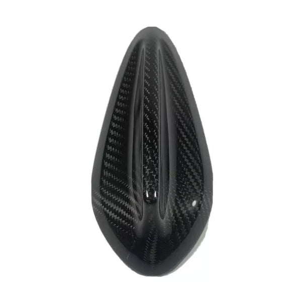 Black carbon fiber object, shaped like a teardrop, featuring aerodynamic grooves. It appears to be a vehicle part, possibly a motorcycle seat cover, set against a plain white background.