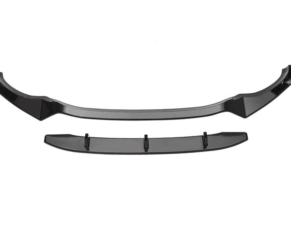Black car front lip spoiler, resting on a white background, consisting of a curved main piece with end attachments and a separate straight component below, likely intended for enhanced aerodynamics.