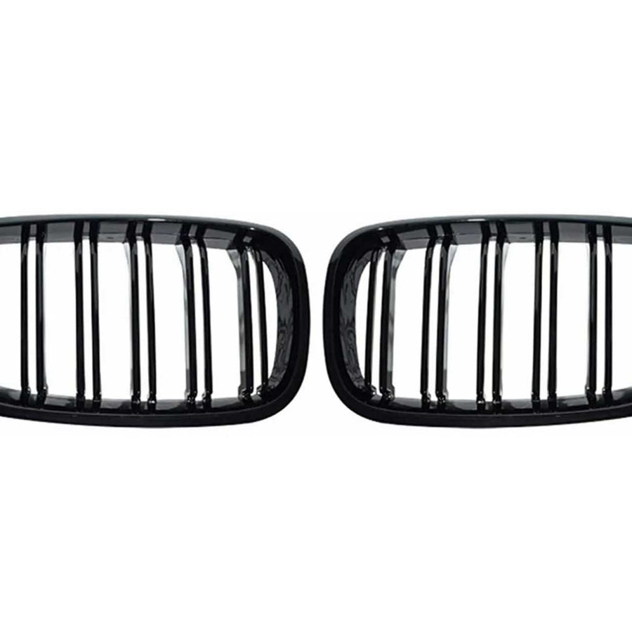 Two black, rectangular car grilles with vertical slats are symmetrically positioned on a plain white background, showcasing a sleek design.