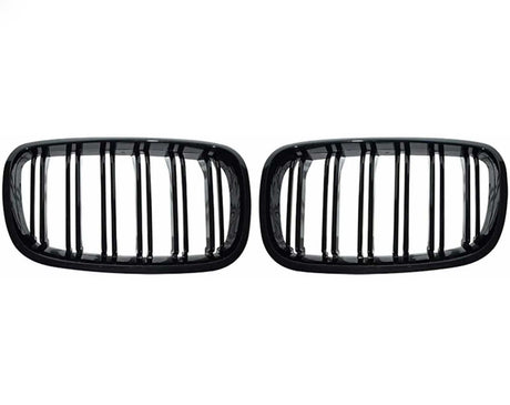 Two black, rectangular car grilles with vertical slats are symmetrically positioned on a plain white background, showcasing a sleek design.