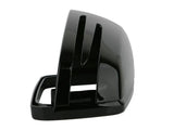 A glossy black, curved plastic object with slots, resembling a vehicle side mirror cover, sits isolated against a plain white background. No text is present.