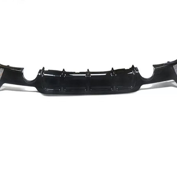 A black car bumper diffuser, featuring glossy finish and aerodynamic grooves, rests on a plain white background, showcasing its sleek design and functionality.