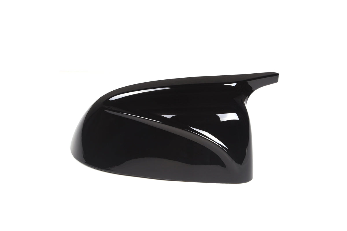 A sleek, glossy black car side mirror cover, angled to the right, placed against a plain white background, reflecting light subtly.