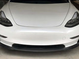 A white car is parked in a garage, focusing on its sleek front design with prominent headlamps and a smooth bumper.