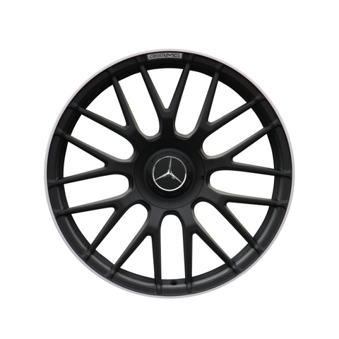A black, multi-spoke car wheel rim with a central emblem and "AMG" text at the top, against a plain white background.