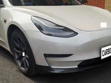 White car with sleek design parked beside brick wall; 