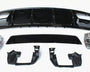 Assorted car parts, including a large black bumper and metallic components, are laid out on a plain white surface, arranged neatly for display or assembly.