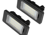 Two rectangular LED lights are placed side by side, featuring black casings and transparent panels with visible bulbs, against a plain white background.