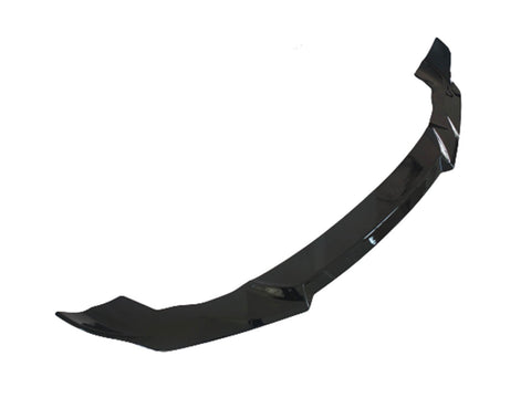A glossy black car front splitter, designed to enhance aerodynamics, lies against a plain white background.