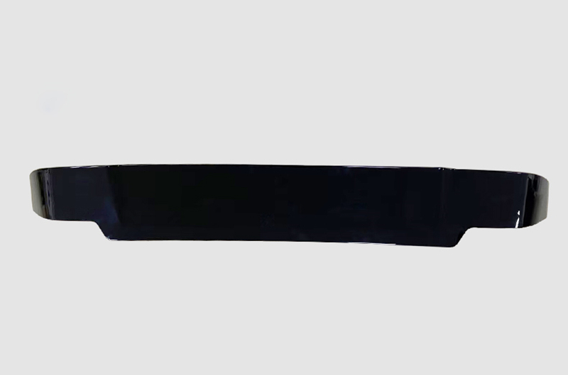 A sleek black car spoiler is shown against a plain gray background, featuring a curved, aerodynamic design with a glossy surface.