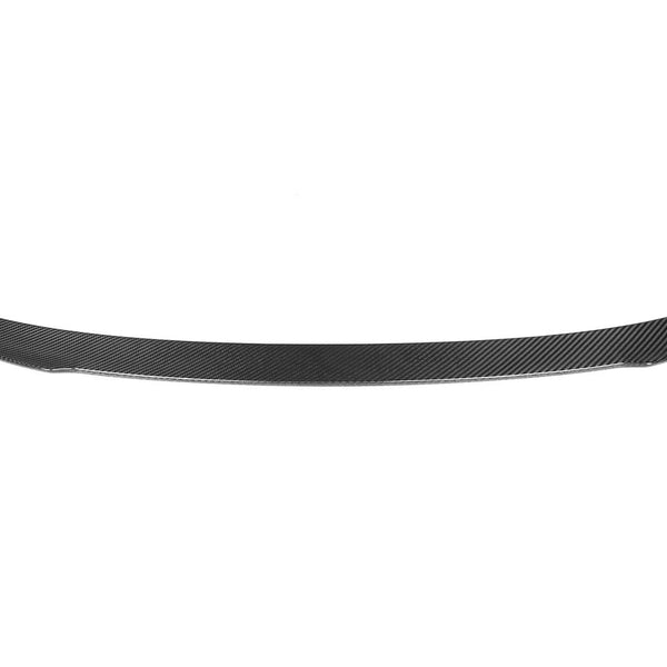 A carbon fiber car spoiler is displayed, streamlined and slightly curved, set against a plain white background, emphasizing its sleek, lightweight design.