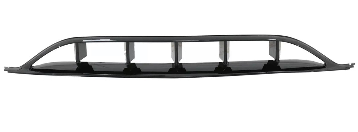 A black car grille features rectangular air vents, resting stationary against a plain white background, highlighting its sleek, aerodynamic design.