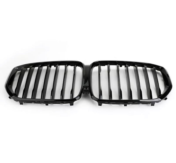 A black, dual kidney-shaped car grille features vertical slats, designed for a vehicle's front end. It rests against a plain white background, emphasizing its sleek design.
