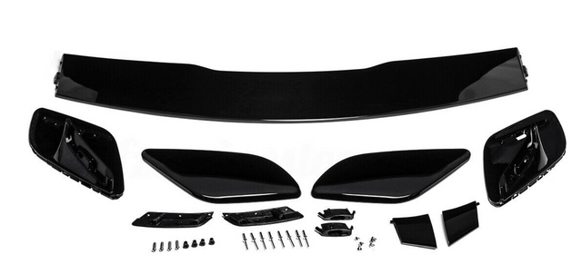 Car spoiler kit with black aerodynamic components laid out on a white surface. Includes a large wing, side pieces, and multiple small parts and screws for assembly.