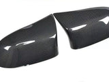 Carbon fiber car mirror covers, positioned side by side, displaying a glossy surface with visible texture, set against a plain white background.