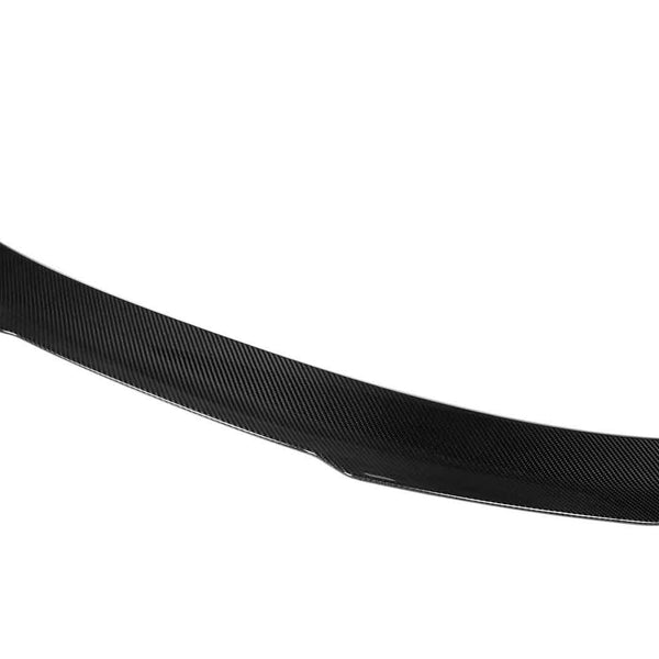 A sleek, black carbon fiber spoiler, slightly curved, sits isolated against a plain white background.