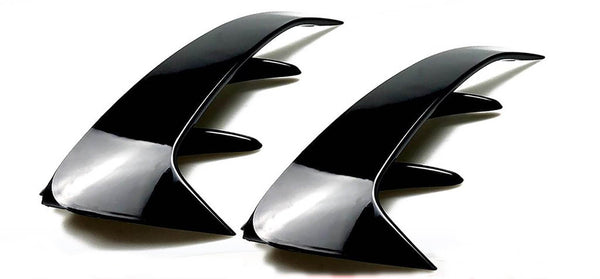 Two sleek, black, curved automotive fins with angular protrusions are positioned side by side on a plain white background, emphasizing their glossy finish and aerodynamic design.