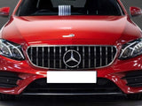A red Mercedes-Benz car, viewed from the front, with prominent grille and headlights. It's parked indoors on a tiled floor, with a blurred background. No text visible.