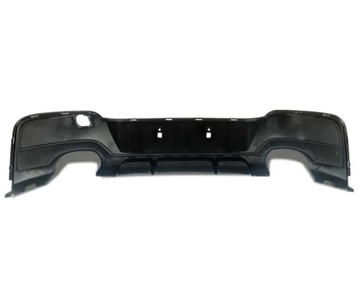 Black car bumper with cutouts for exhaust and mounting. The bumper is designed for rear attachment, featuring smooth contours and a flat backdrop, isolated on a plain white surface.