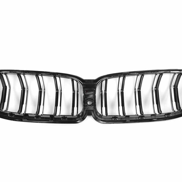 A glossy black car grille with vertical slats lies on a white background, resembling a butterfly shape with symmetrical slots, designed for vehicle front ventilation systems.