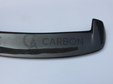 Carbon fiber car spoiler on a white background, featuring a subtle weave pattern and sleek design. Text reads: 