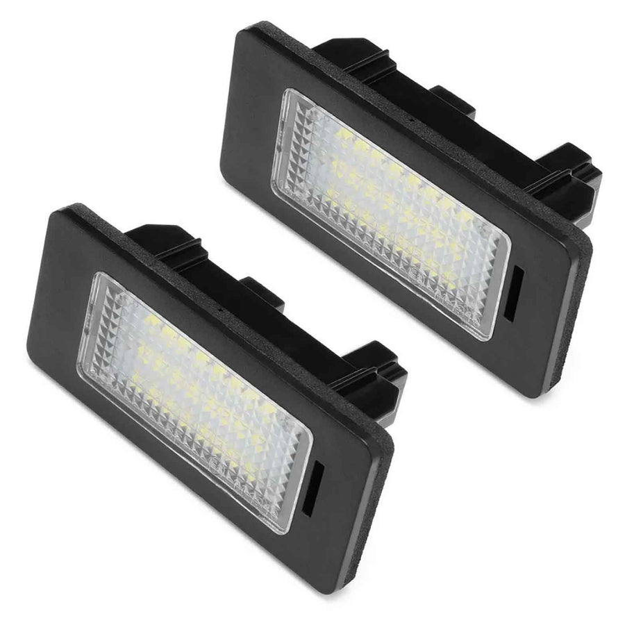 Two rectangular LED license plate lights sit against a white background, featuring black frames and clear, patterned lenses enclosing multiple small yellow LEDs.