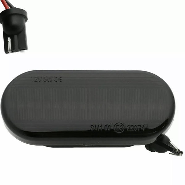 An oval black car side marker light labeled "12V5W CE SM1 06 (E9) 22974," with a socket and exposed wiring, set against a plain background.