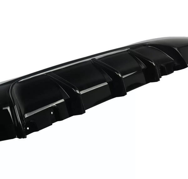 A black car bumper features multiple vertical fins, designed for aerodynamics, set against a plain white background.