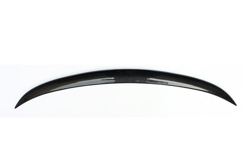 A glossy, black carbon fiber car spoiler arcs gracefully, displayed against a plain white background, highlighting its sleek and aerodynamic design.