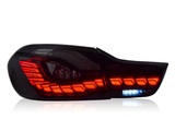 A sleek car taillight glows bright red with segmented LED patterns, featuring a small section of white LEDs, set against a plain white background.