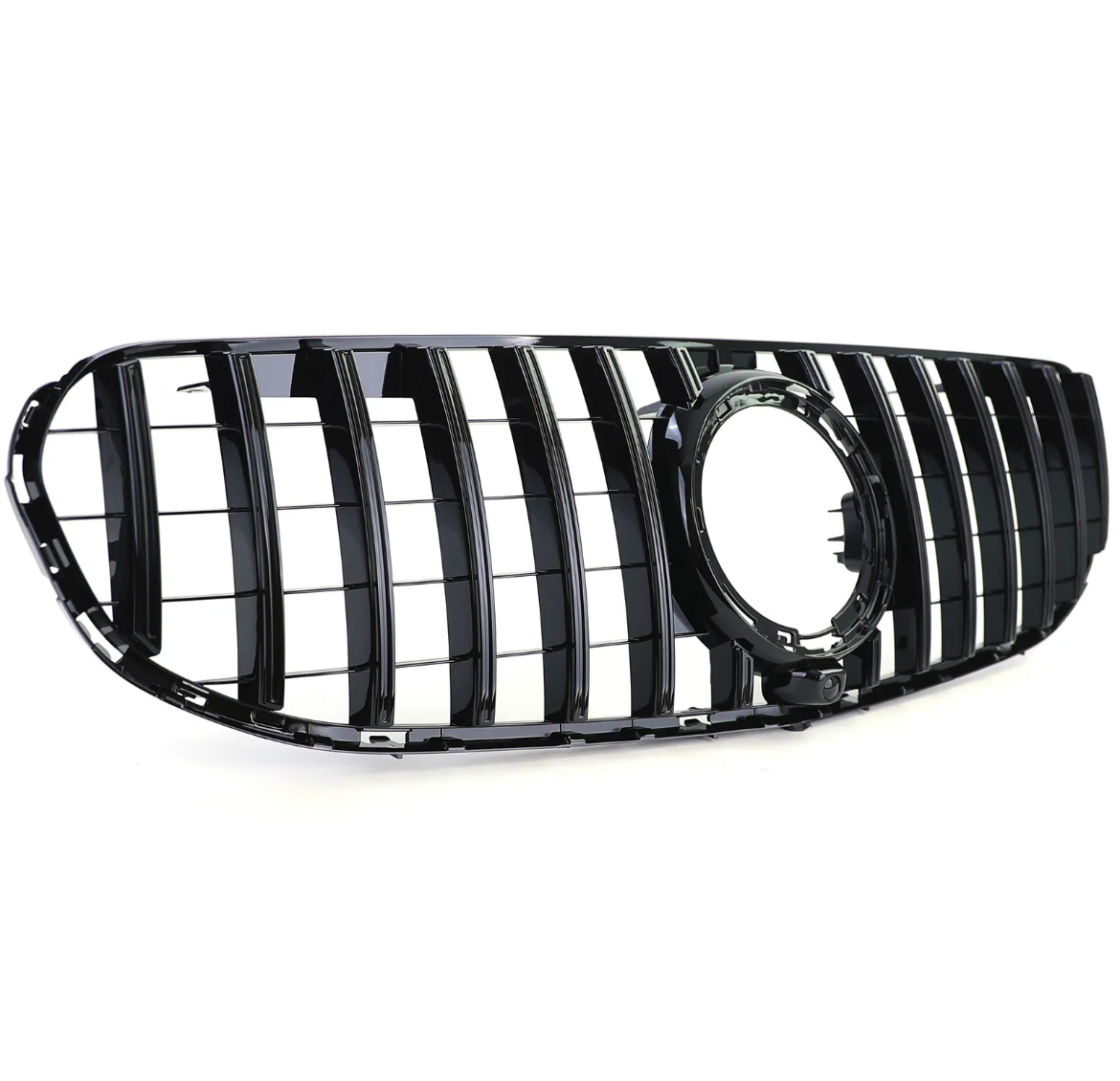 A glossy black car grille features vertical slats and an empty circular emblem holder, set against a plain white background.