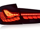 A sleek, modern car taillight, illuminated in bright red with intricate patterns, set against a plain white background.