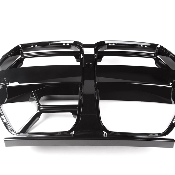 A shiny black car grille, featuring two adjacent rectangular openings, lies on a plain white background. The grille has a glossy, reflective surface with a symmetrical design.