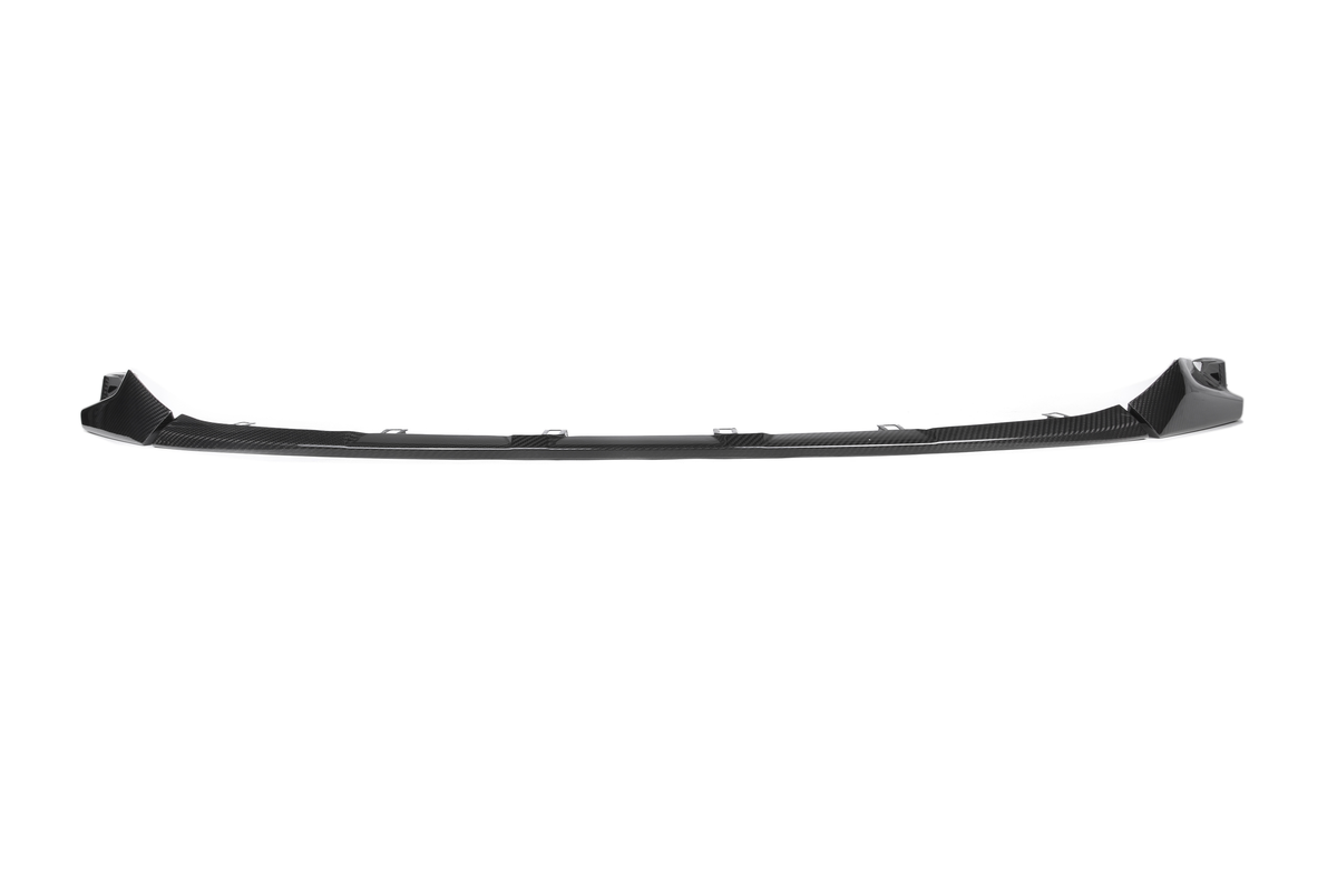 A black, curved automotive bumper spoiler is positioned horizontally against a white background, designed for aerodynamics with integrated attachment points.