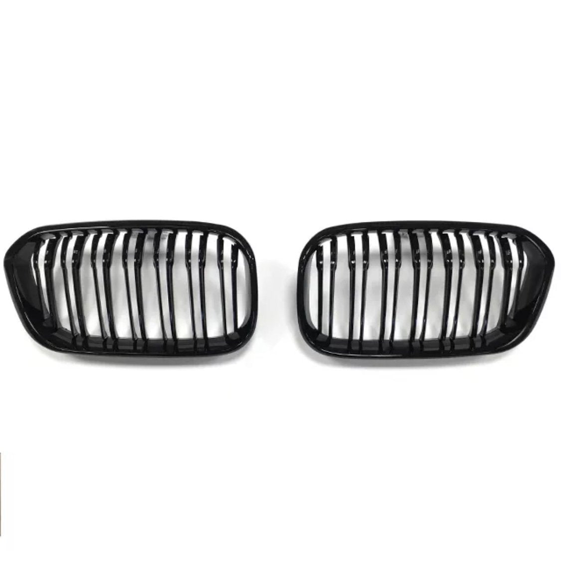 Two black car grilles, each with vertical slats, are positioned side by side against a plain white background.