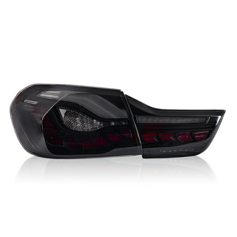 A black LED car taillight with a sleek, angular design and red accents, shown on a reflective white surface, suggesting an automotive context.