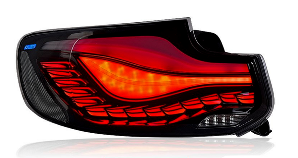 A car taillight with flowing red LED patterns and a yellow indicator section, encased in a glossy black frame. A small label reads "OLED" in the corner.