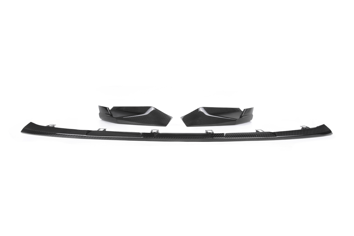 A set of black carbon fiber car parts, including a split lip spoiler and two corner extensions, displayed on a plain white background.